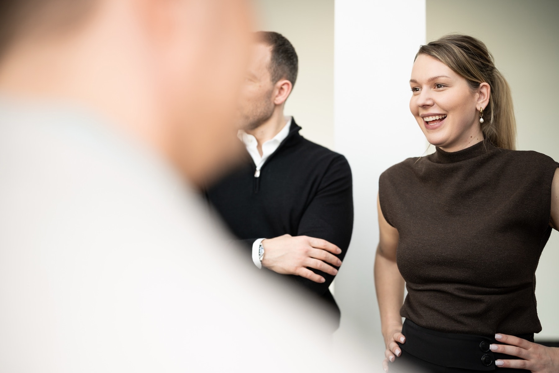 Nadia Wiegand im Gespräch, lachend, im Hintergrund zwei weitere Personen in einem hellen Raum